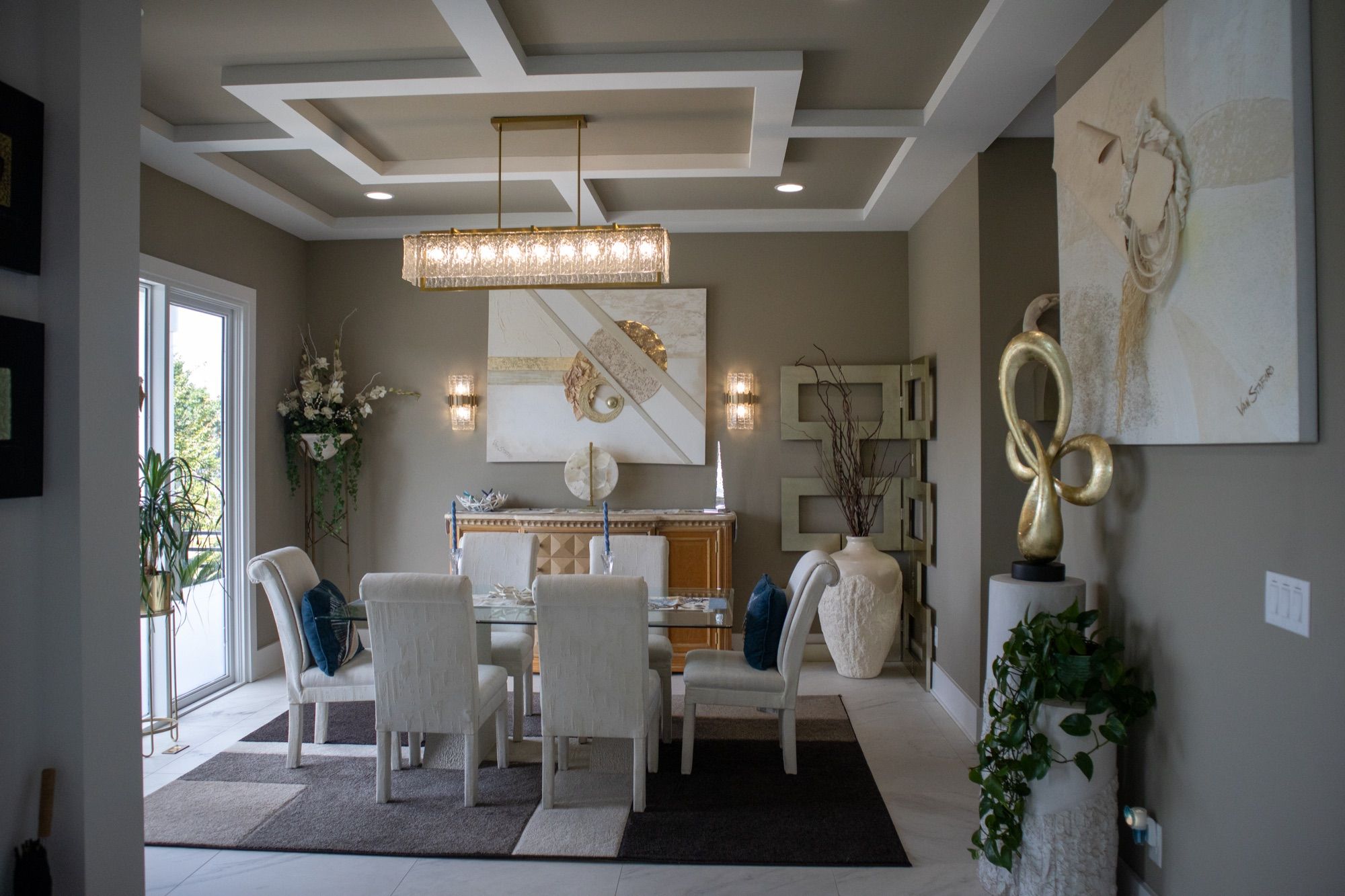A formal dining room with a coffered ceiling in a Lackey Luxury home.