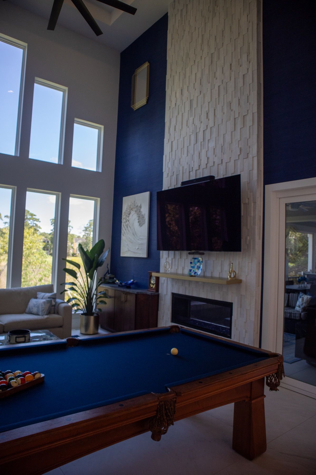 A game room with a navy feature wall and a full-size pool table.