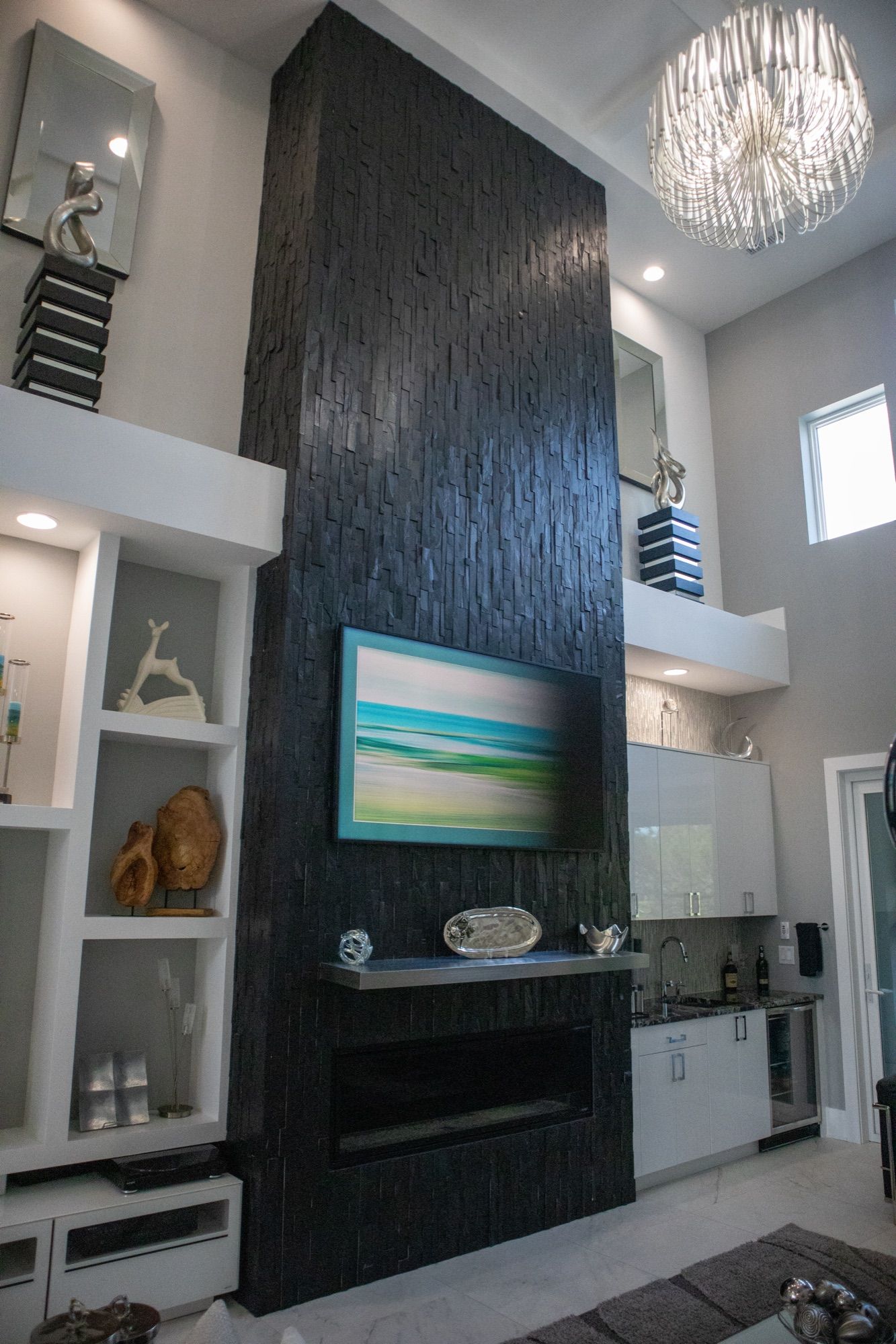 A living room with a floor-to-ceiling tiled fireplace and built-ins.
