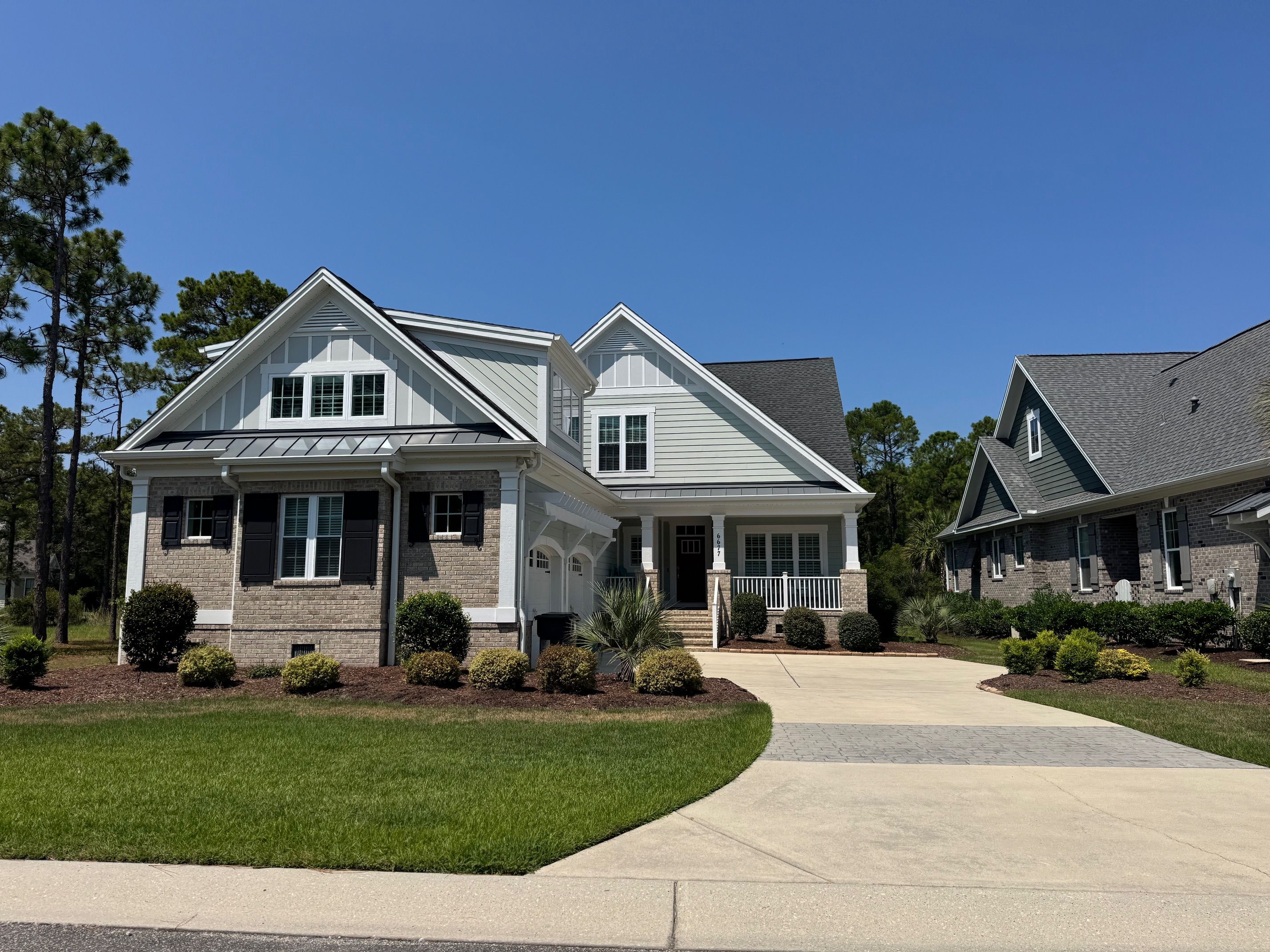 Brick base, white columns and a full front porch on a quiet street.