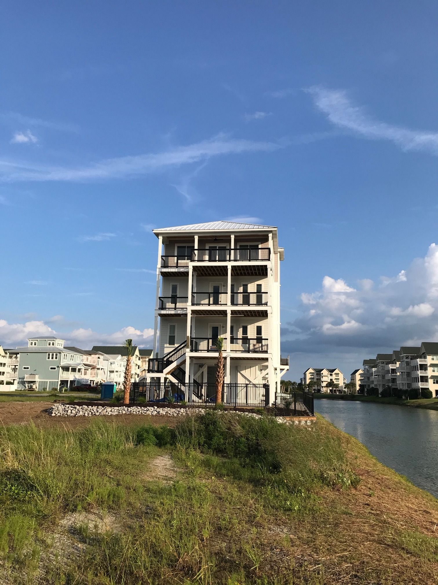A four-story home up on pilings by the water, built for salt air, storm season and a view from every floor.